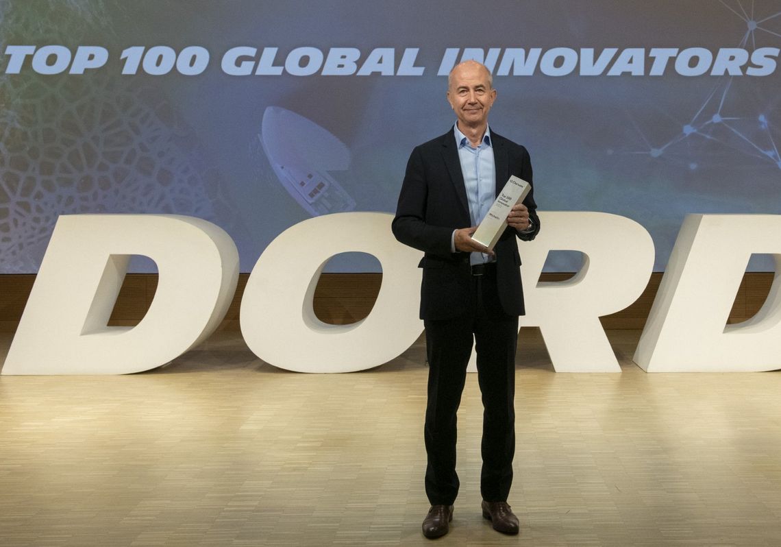 Éric-Philippe Vinesse holding a trophy in his hands. In the background, a video projection reads: “TOP 100 Global Innovators 2023”. DORD (R&D Operational Direction)