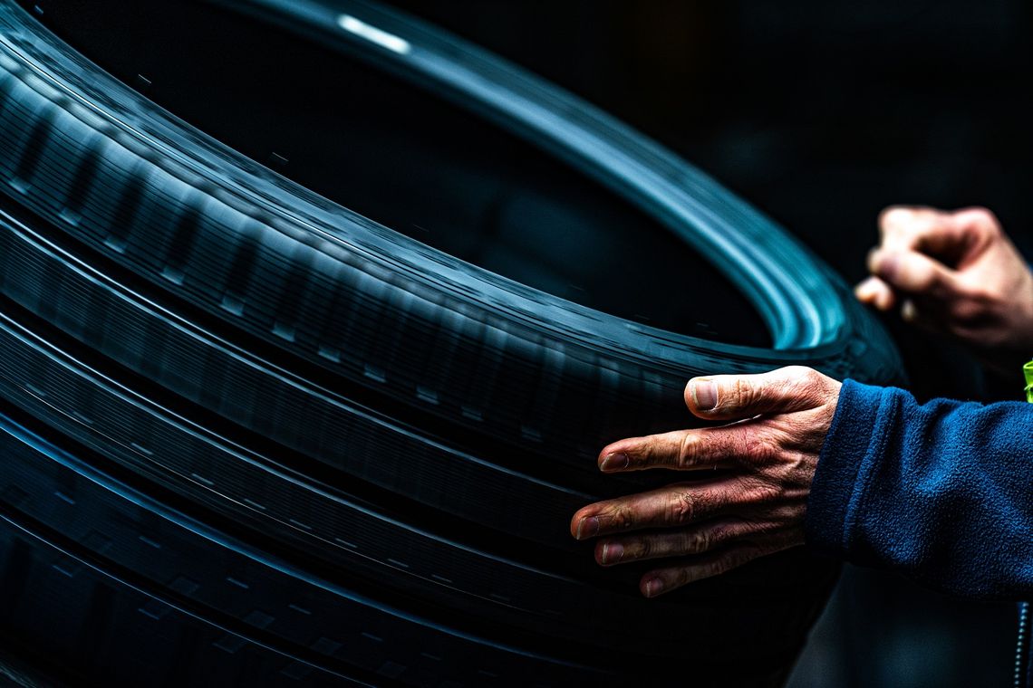Un employé Michelin contrôle la qualité du pneumatique de manière tactile et visuelle