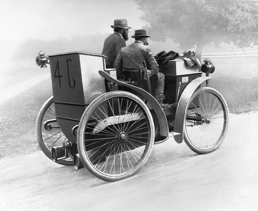 Illustration en noir et blanc montrant André Michelin au volant de "l'Eclair", un homme est assis à sa droite, côté passager. La voiture porte le numéro 46 à l'arrière.