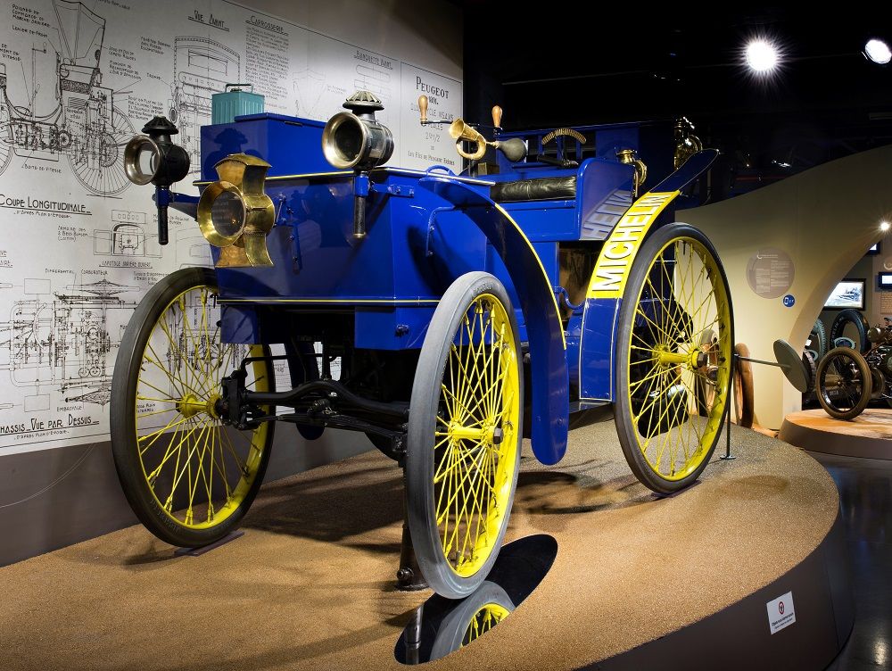 Photographie d'une réplique de "l'Eclair". Le véhicule arbore les couleurs bleu et jaune, caractéristiques de la charte graphique du Groupe.